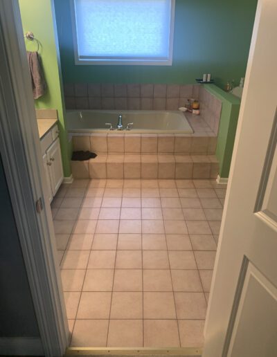 A bathroom with a bathtub and tiled floor.