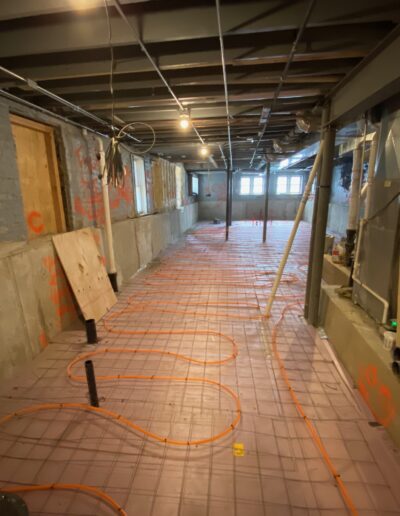 A hallway with orange hoses and pipes.