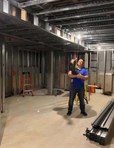 A man standing in a room with metal framing.