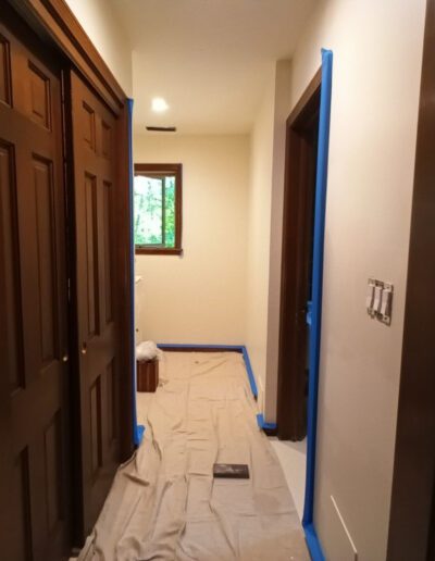 A hallway is being painted with blue paint.