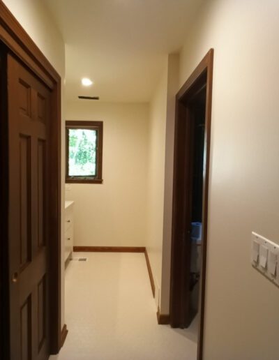 A hallway with wooden doors and white walls.