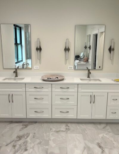 A white bathroom with two sinks and mirrors.