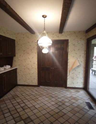 An empty kitchen with tile floors and a sliding glass door.