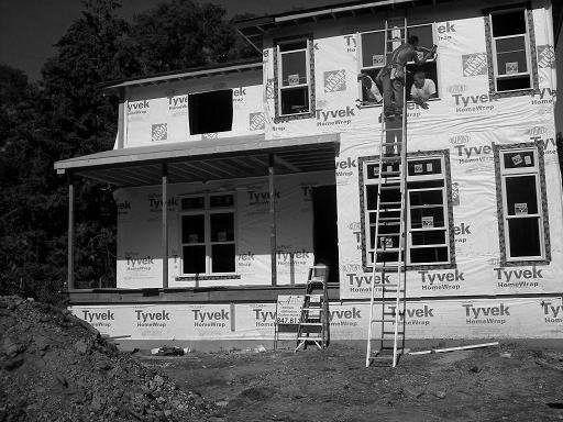 A black and white photo of a house under construction.